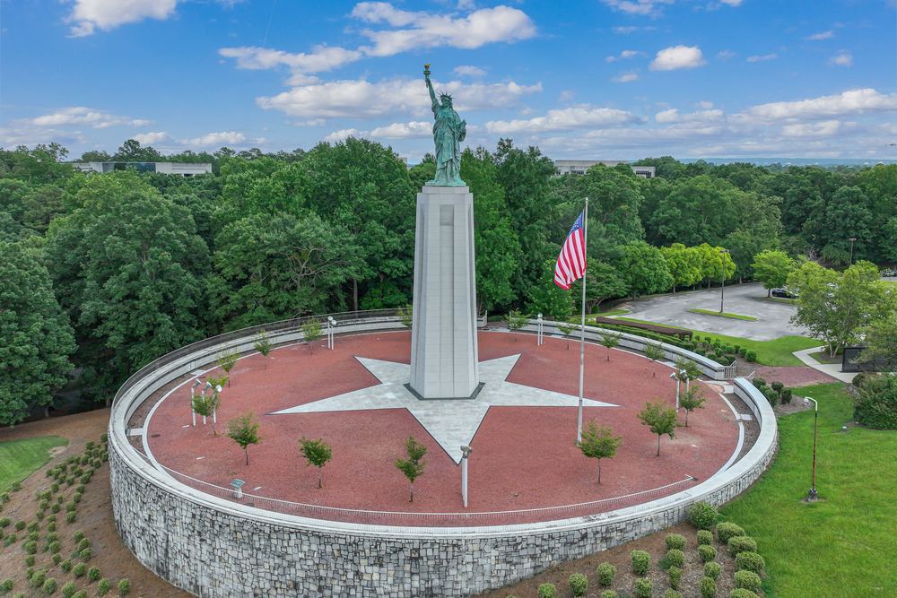 The Liberty statue on its stone base with an American flag beside it